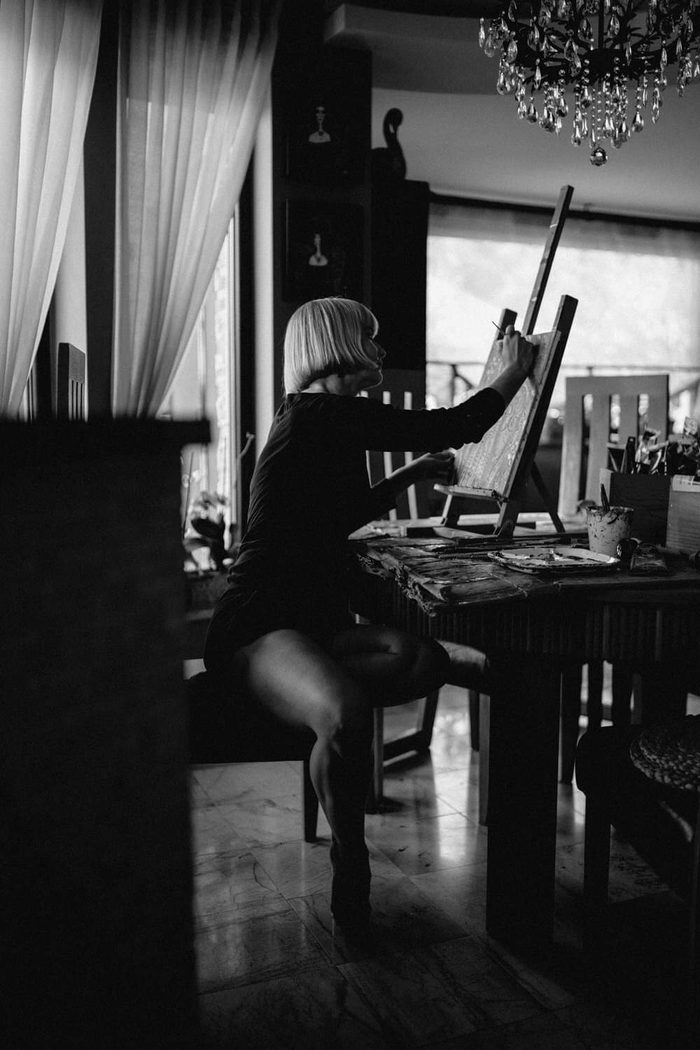 Katarzyna Krauze-Romejko malująca przy sztaludze, fotografia czarno-biała