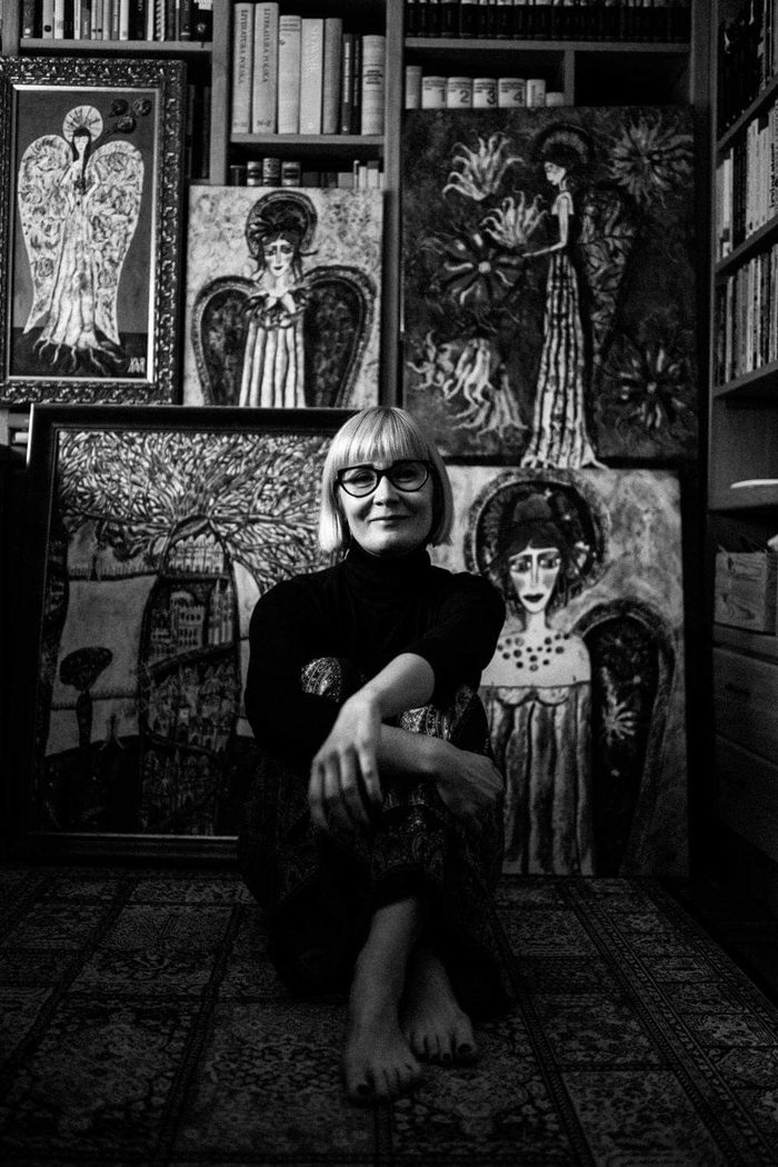 Artystka w pracowni wśród obrazów aniołów, fotografia czarno-biała